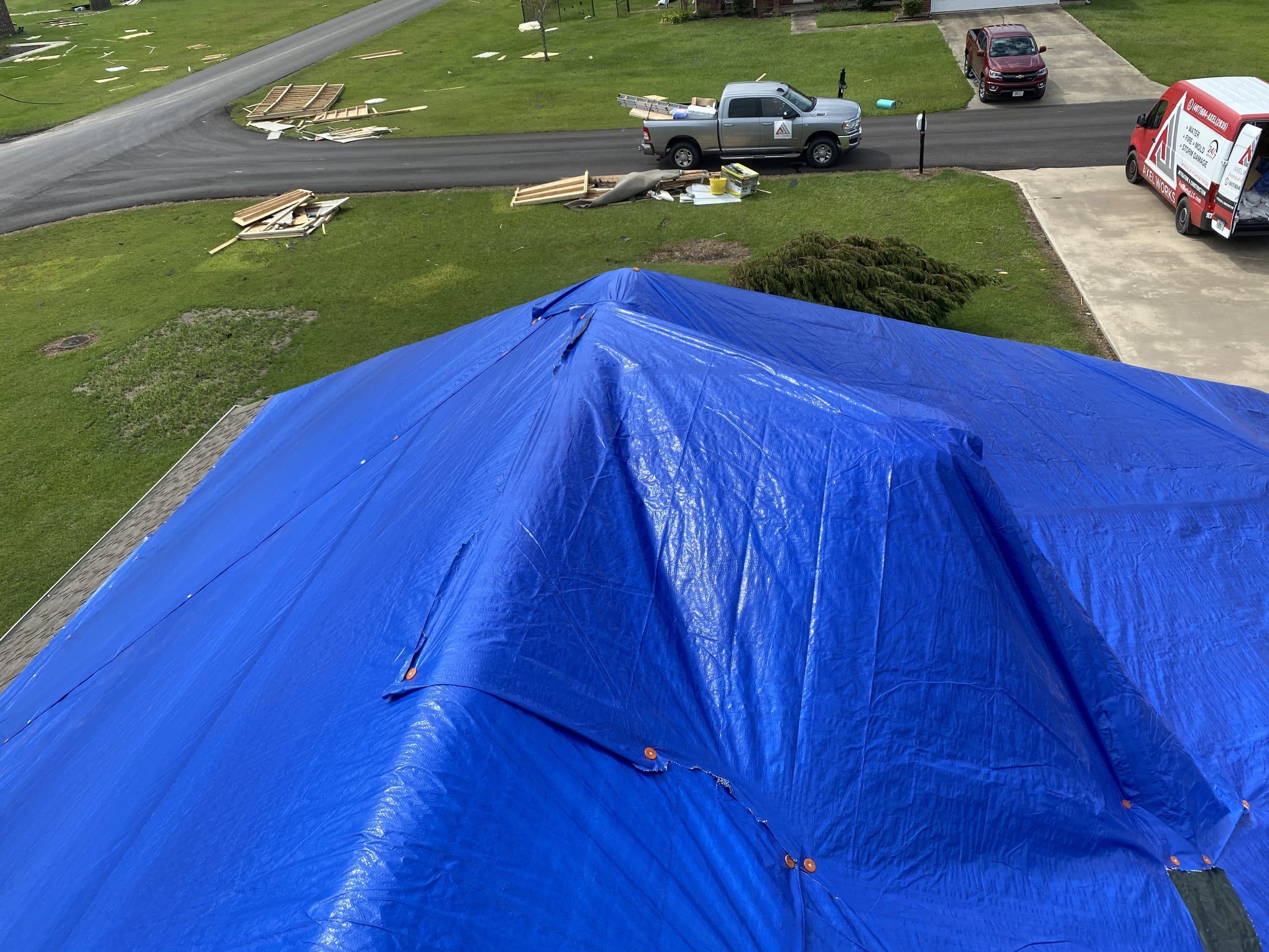Blue tarp on top of a roof placed by Axel Works